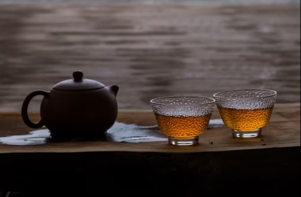 A teapot with two cups of tea.