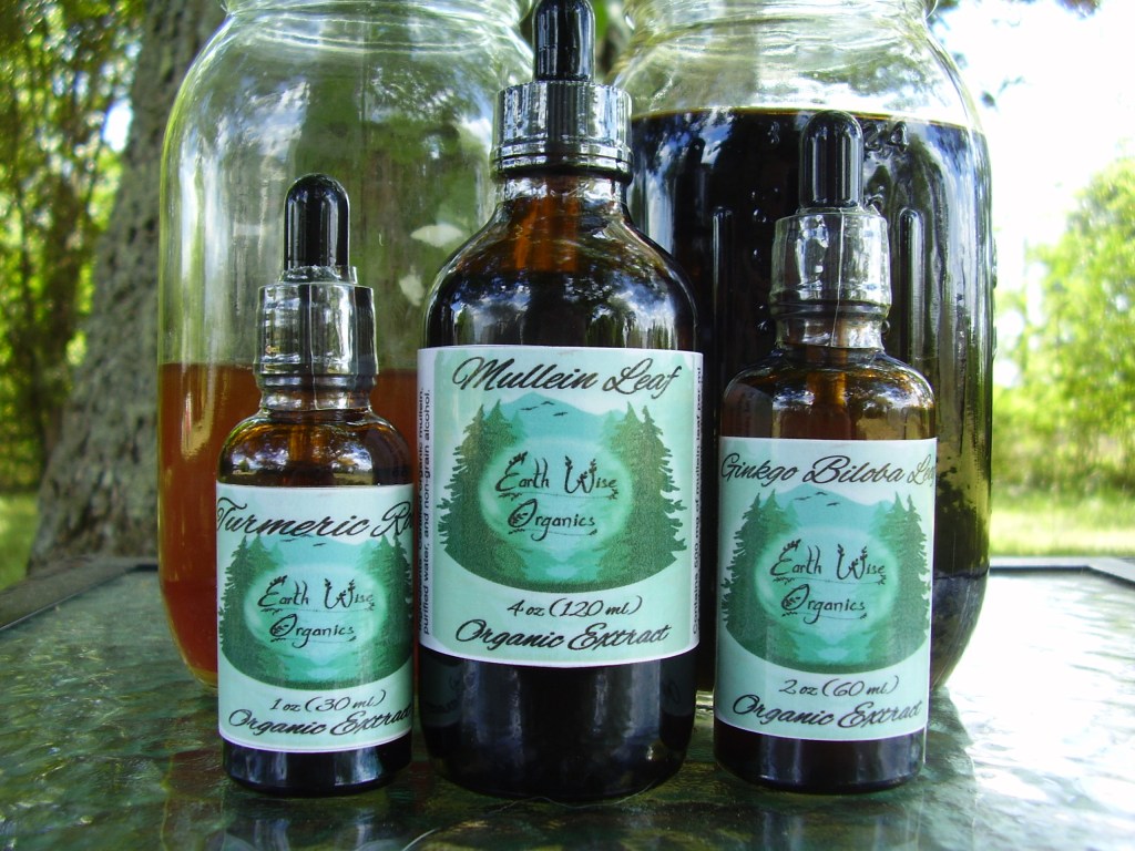 Three tincture bottles side by side in front of two mason jars with tincture in them.