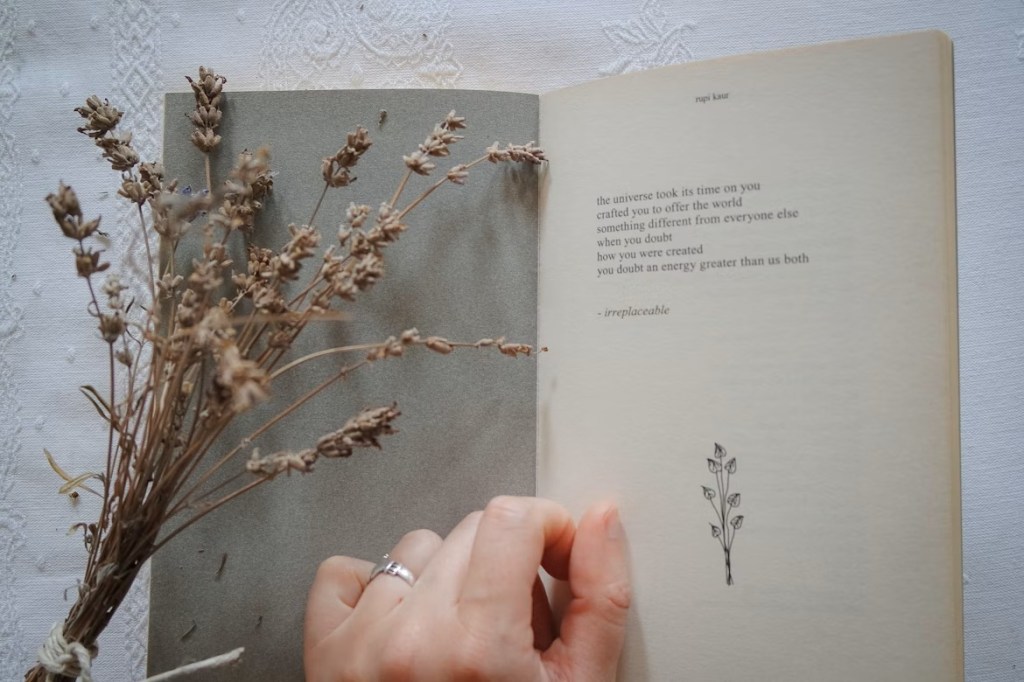 Notebook with bundle of dried herbs and hand on page.