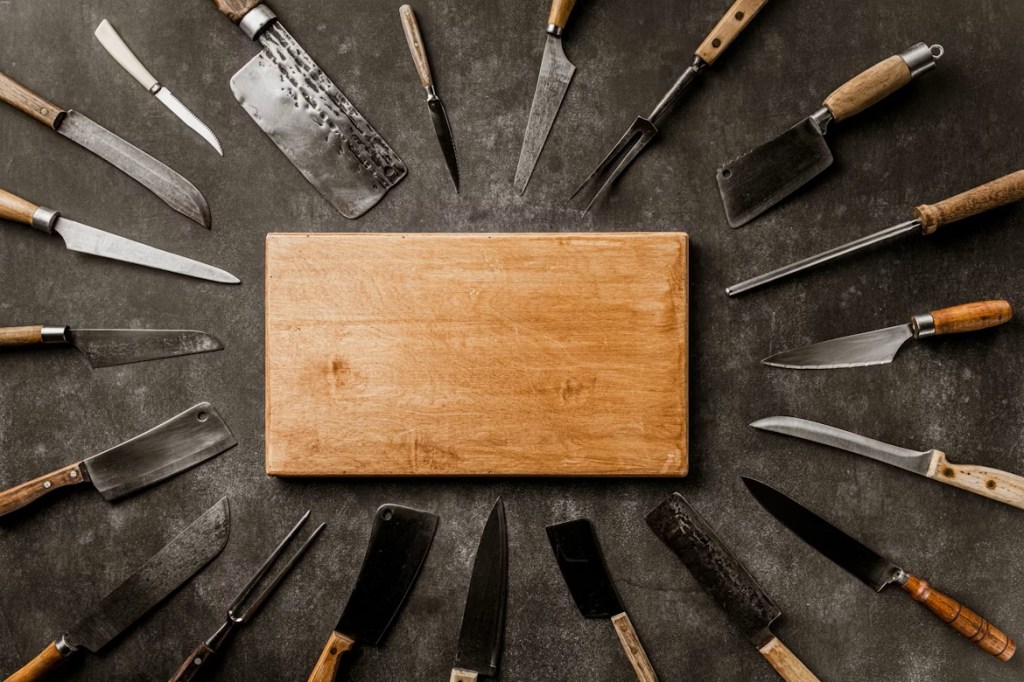 Wooden cutting board with kitchen knives surrounding it.