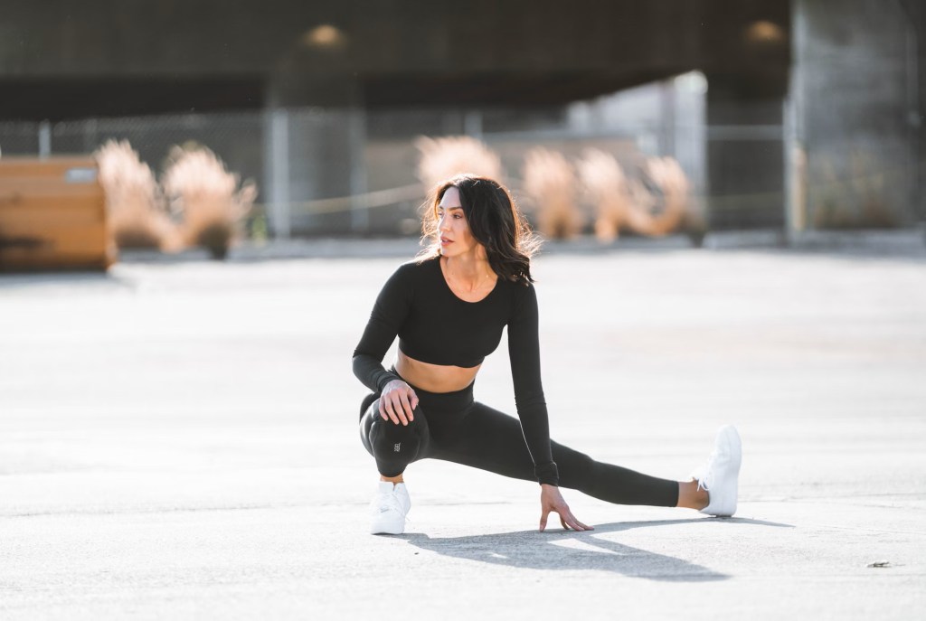 woman outside posed in trainer stretch