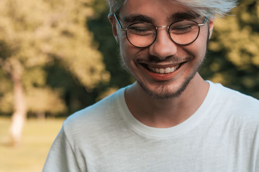 Smiling man with glasses outdoors. 